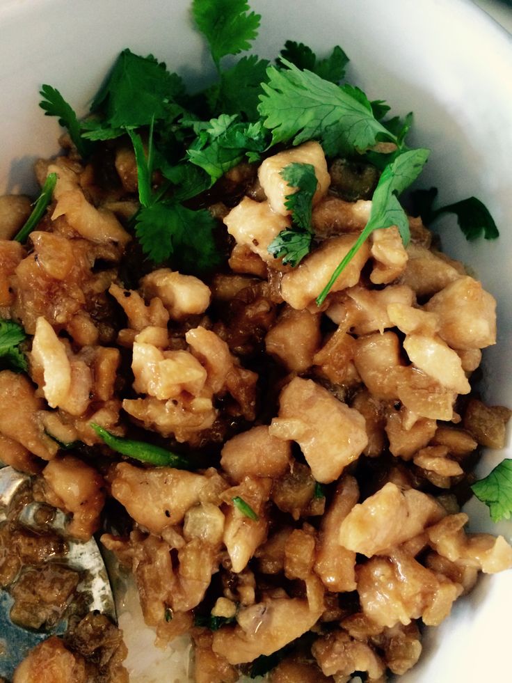 a white bowl filled with food and garnished with cilantro