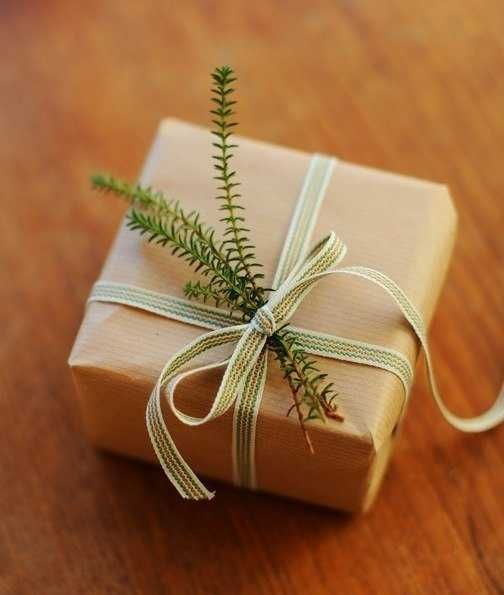 a wrapped present sitting on top of a wooden table next to a string and twine