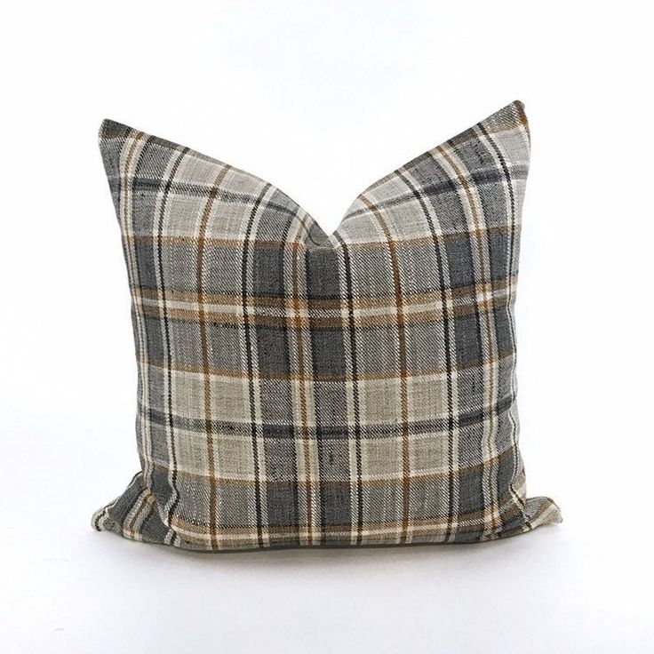 a plaid pillow is shown on a white surface with a black and tan checkered pattern