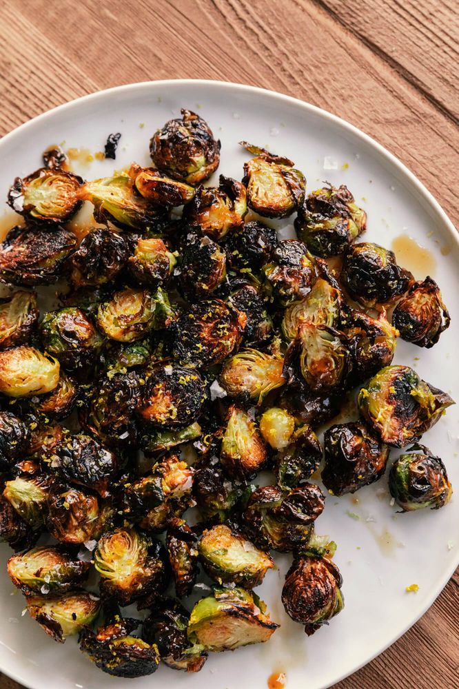 a white plate topped with brussel sprouts on top of a wooden table