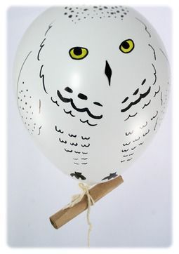 a white owl balloon with yellow eyes and a stick attached to it's head