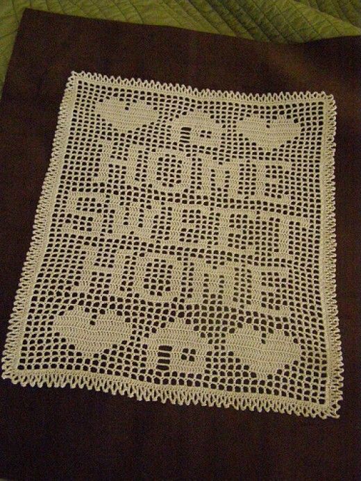 a white crocheted doily on top of a brown table cloth with black trim