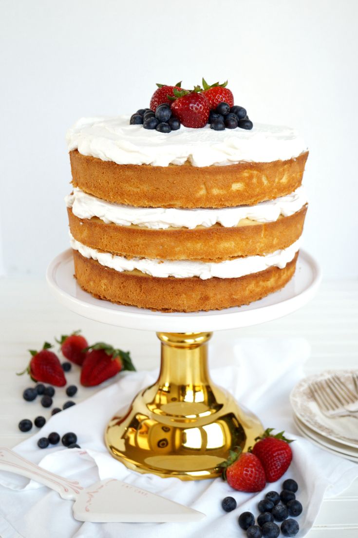 a cake with white frosting and berries on top