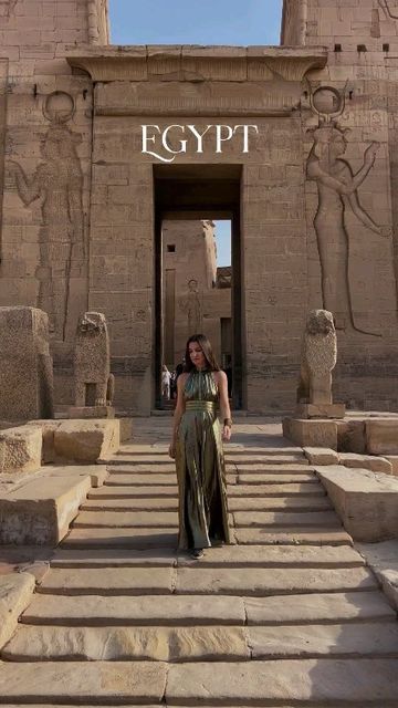 a woman standing in front of an egyptian temple