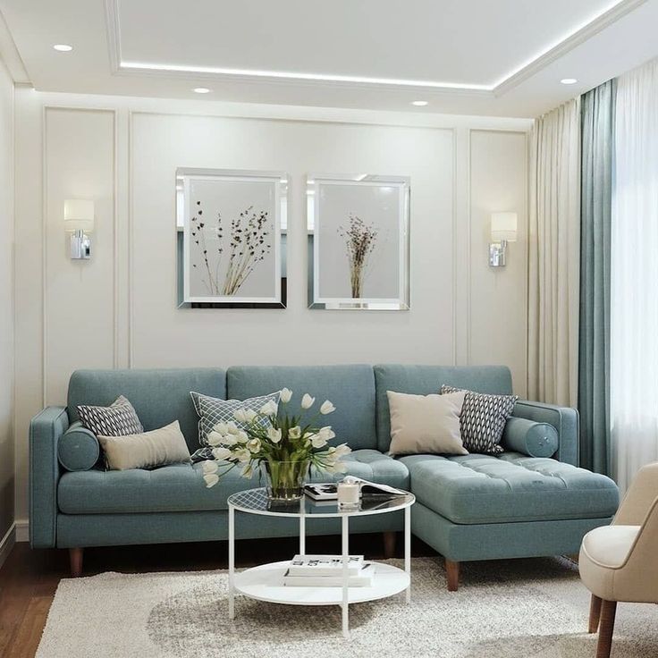 a living room with blue couches and white rugs on the hardwood flooring