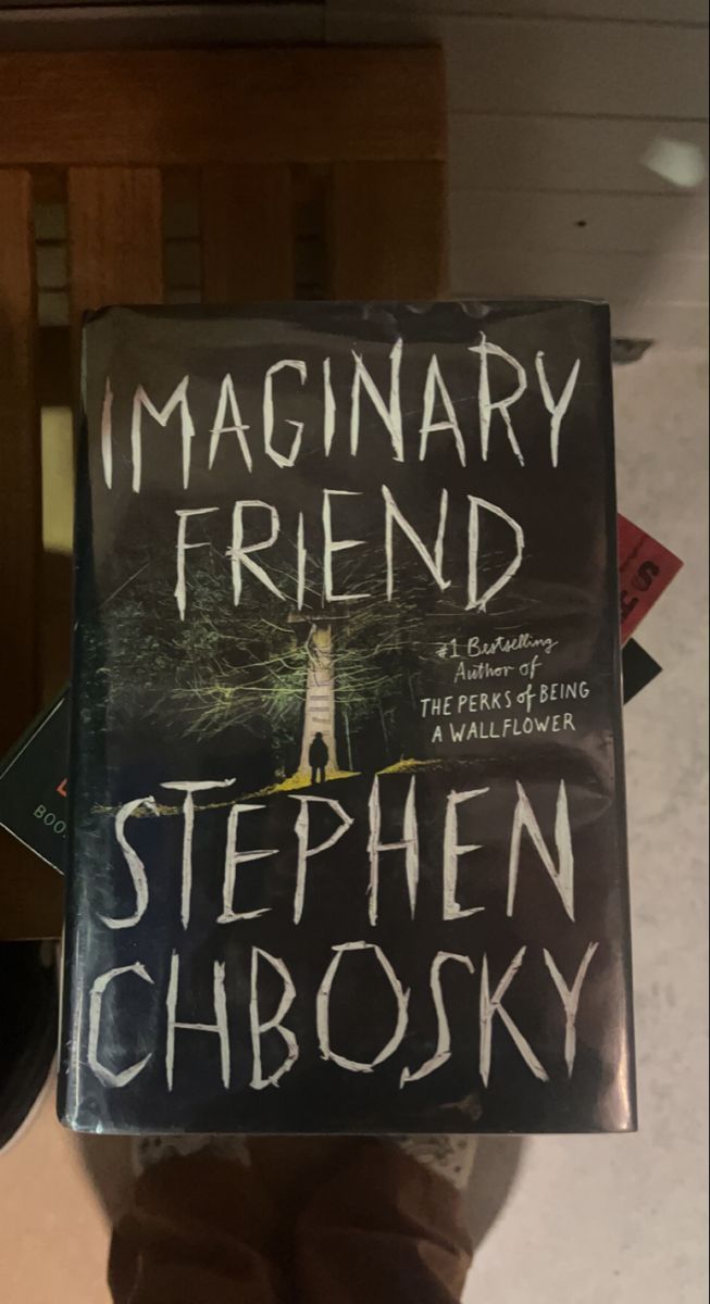 a person holding up a book in front of their face with the title imaginary friend written on it