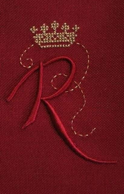 the letter r is stitched on to a piece of red fabric with gold thread