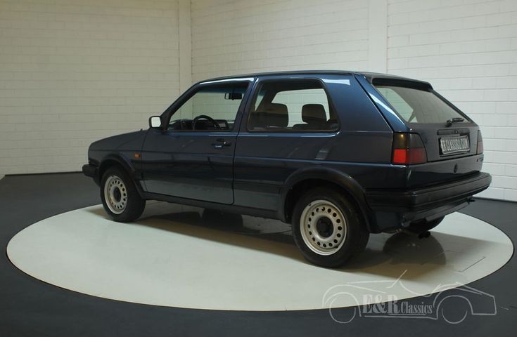 a black car parked in a garage next to a white wall