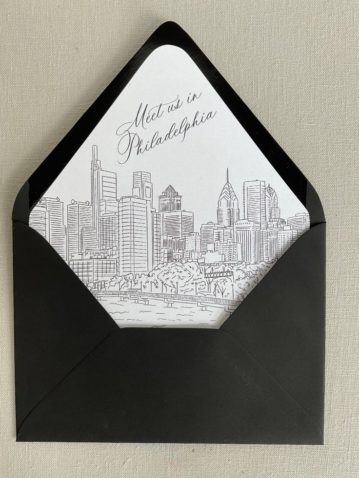 a black envelope with a drawing of a city on it and the words, meet us in philadelphia