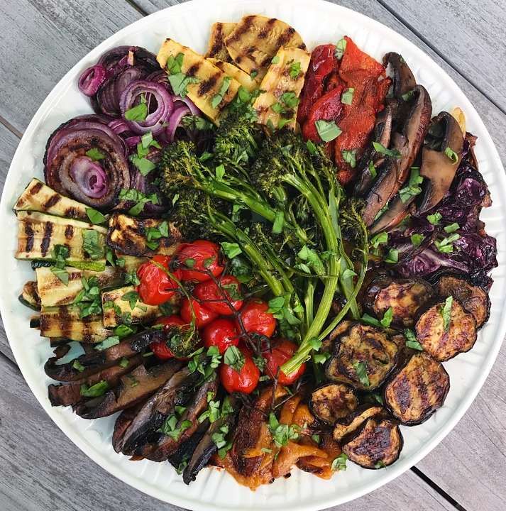 a white plate topped with grilled vegetables and meat