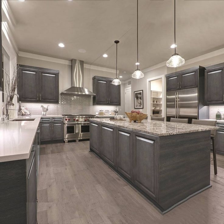 a large kitchen with stainless steel appliances and wood flooring