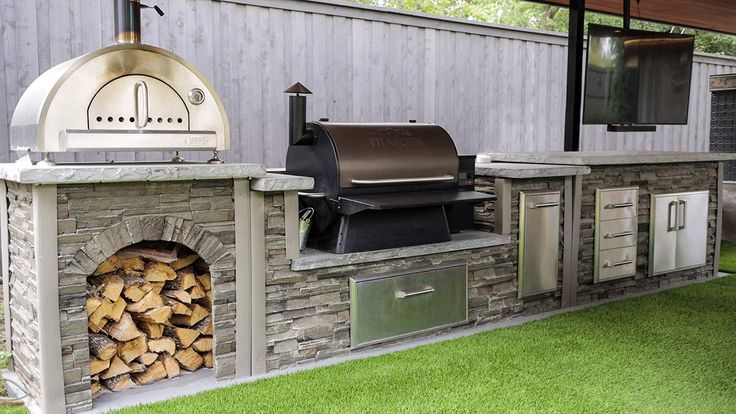 an outdoor bbq grill with firewood stacked in it