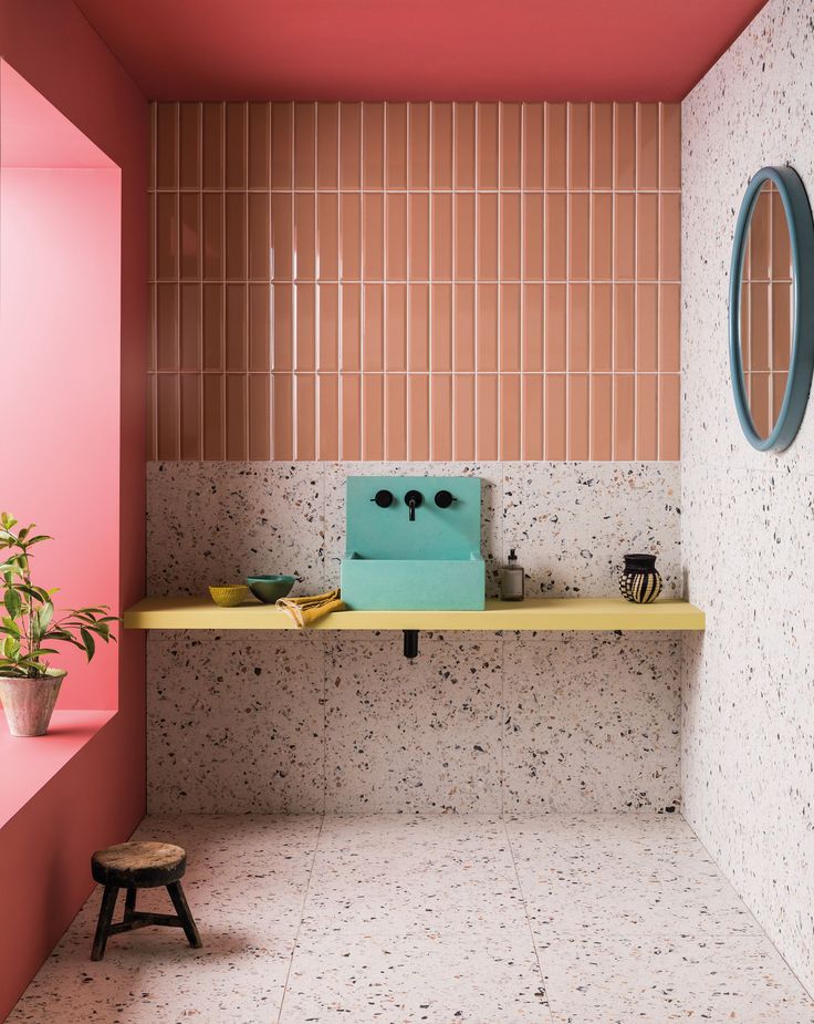 a bathroom with pink walls and tiled flooring next to a yellow shelf on the wall