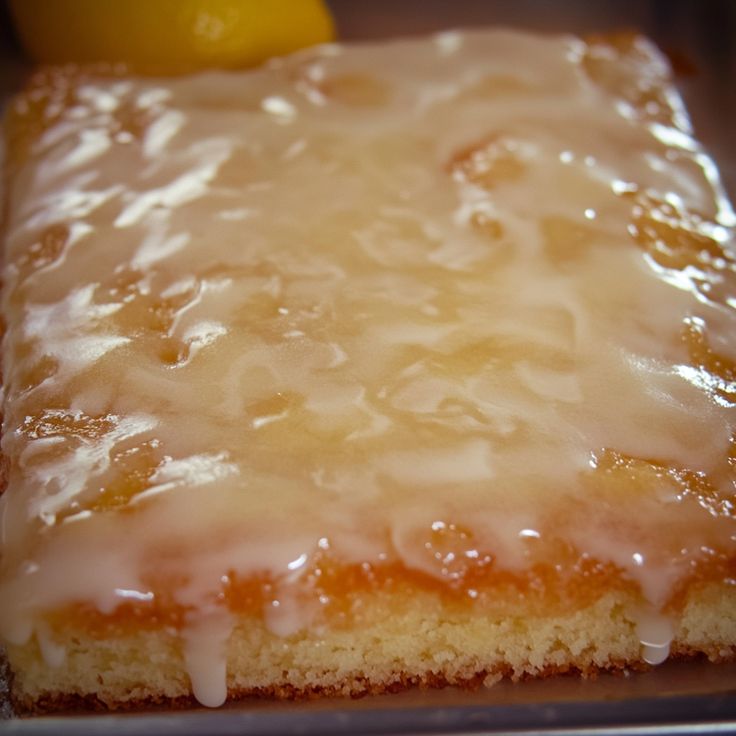 a close up of a piece of cake with icing and lemons on it