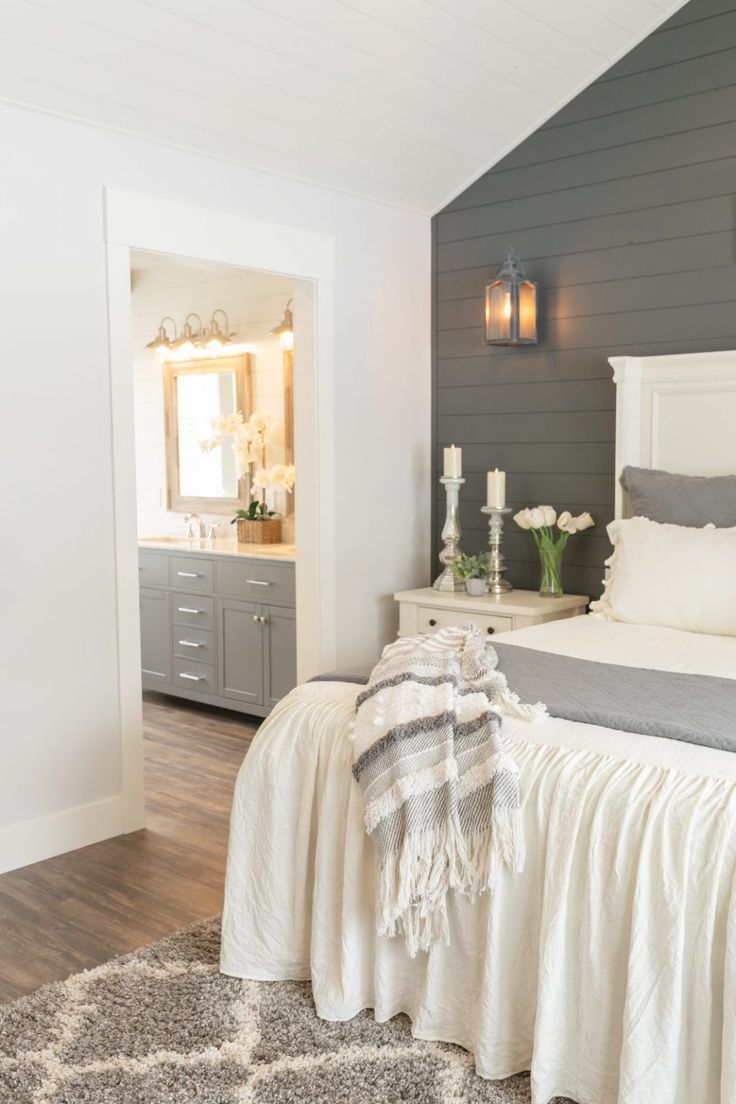 a bedroom with gray walls and white bedding