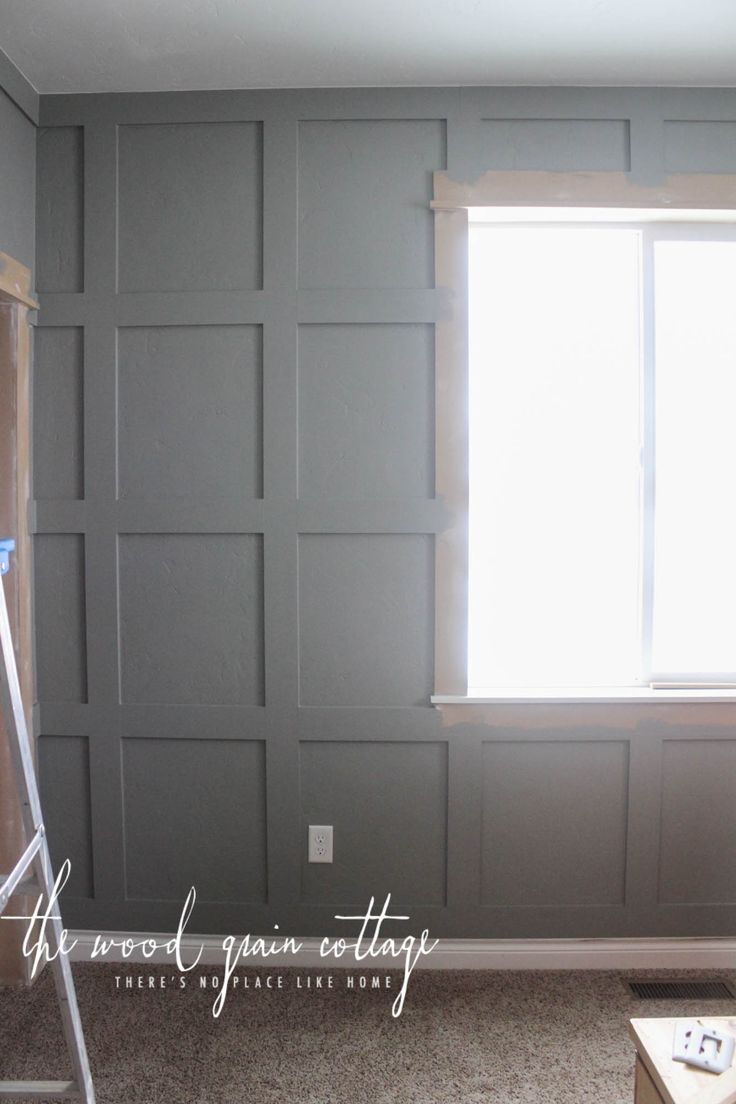 an empty room with gray walls and white trim on the window sill is being painted