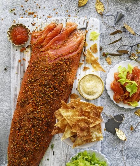 a large fish is on a platter with chips and sauces next to it