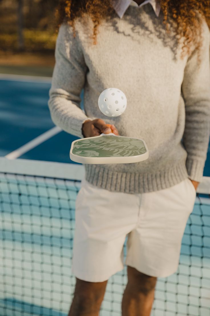 a person holding a tennis racket and ball