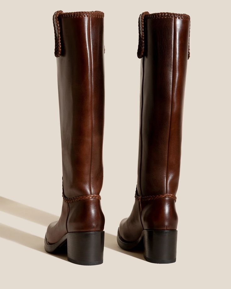 Heeled Square-Toe Braided Detail Knee-High Boot Heeled knee-high boots with braided details. Made in Spain by a traditional riding boots factory, celebrating excellence in craftsmanship. · Colour: Brown· Braided detail· Pull-on knee-high boot· Heel height: 6.5 cmsEuropean sizing. Fits true to size. Jeans And Knee High Boots Outfit, Brown Riding Boots Outfit, Knee Length Brown Boots, Brown Knee High Boots Outfit, Ireland Clothes, Long Brown Boots, English Riding Boots, Riding Boot Outfits, Brown Knee Boots