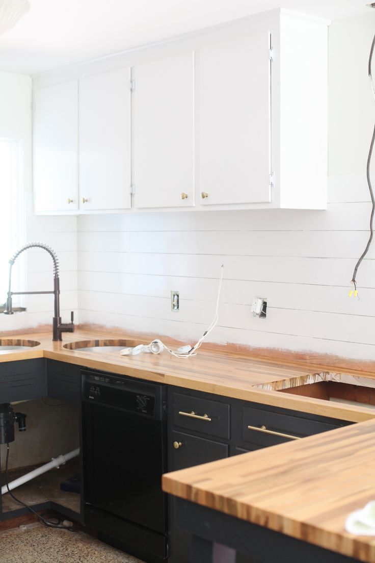 a kitchen with white cabinets and black appliances