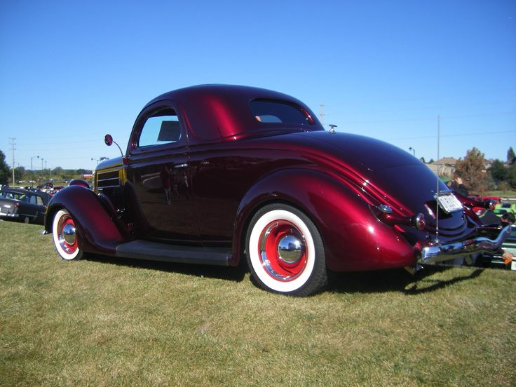 an antique car is parked on the grass