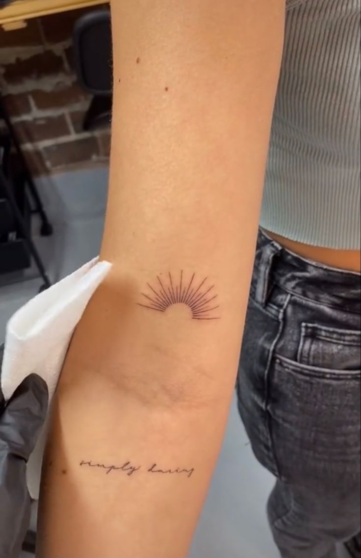 a woman's arm with a tattoo that says simply sunny on the inside of it