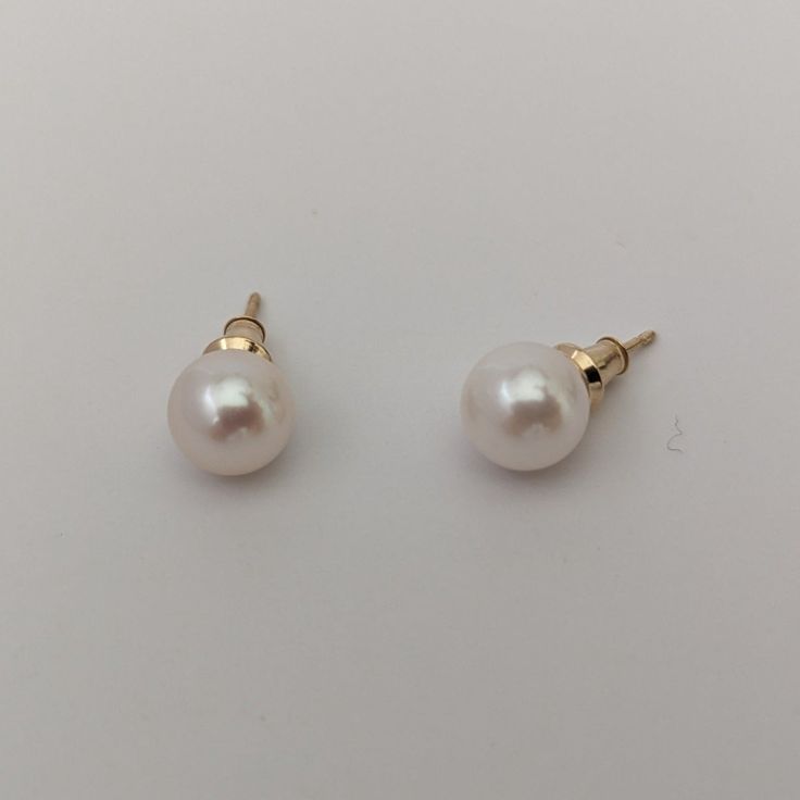 These earrings, featuring cultured saltwater Akoya pearls set in 14K yellow gold, provide a classic and timeless style that enhances any outfit. The round pearls measure 7.5-8.0mm in size, displaying a stunning luster and a bright white color that's beautifully amplified by their natural orient. Set in a versatile stud style, the earrings are suitable for both everyday wear and special occasions. With a lightweight design, they ensure comfort throughout the day. The pearls' clean surface, free f Classic Akoya Pearl Earrings For Formal Occasions, Classic Gold Pearl Earrings, Classic Yellow Gold Pearl Earrings For Formal Occasions, Classic Pearl Earrings In Yellow Gold, Classic Gold Round Pearl Earrings, Timeless Round 14k Gold Pearl Earrings, Classic 14k Gold Pearl Earrings, Classic Pearl Earrings With High Luster, Classic High Luster Pearl Earrings