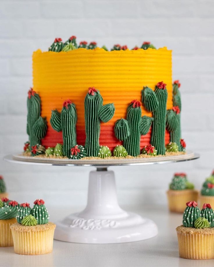 a cake with cactus decorations and cupcakes around it