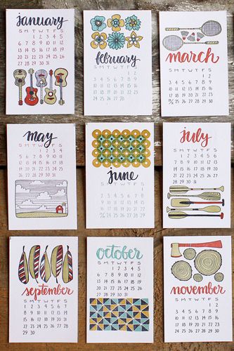 six calendars with different designs on them sitting next to each other in front of a wooden table