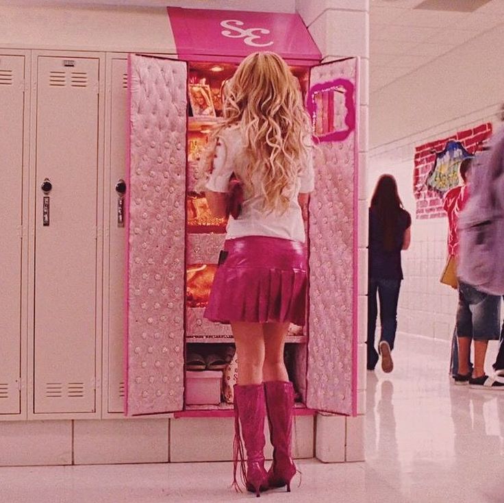 a woman standing in front of a pink refrigerator