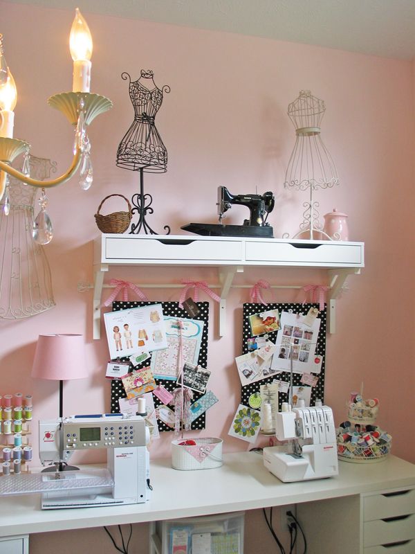 a sewing machine sitting on top of a white table next to a shelf filled with pictures