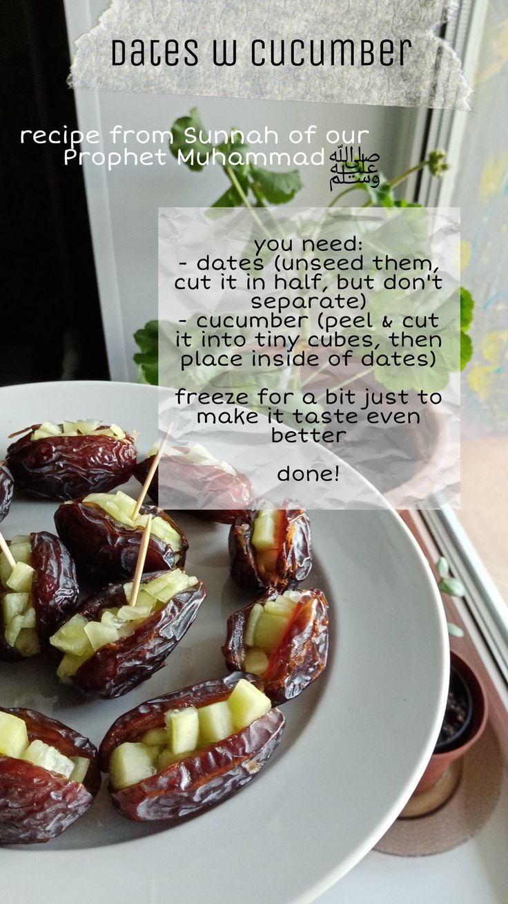 dates and cucumbers on a white plate next to a window