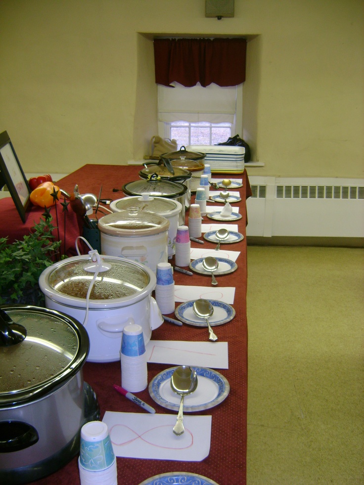 a long table with many plates and bowls on it, all lined up in the same row