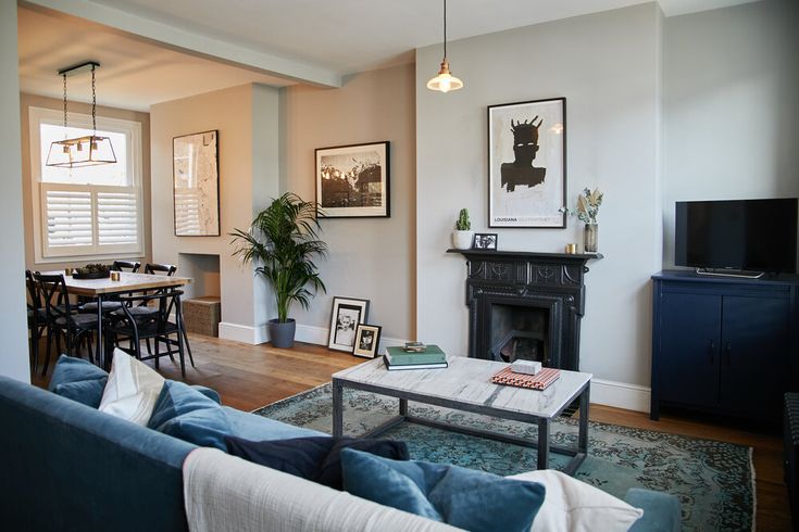 a living room filled with furniture and a fire place in front of a flat screen tv