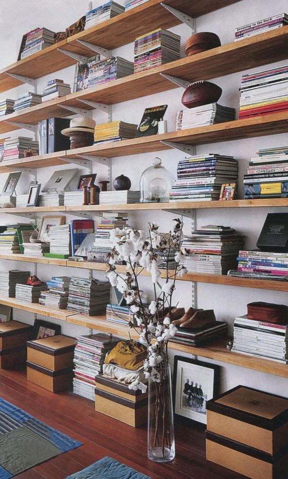 a room filled with lots of books and vases on top of shelves next to each other