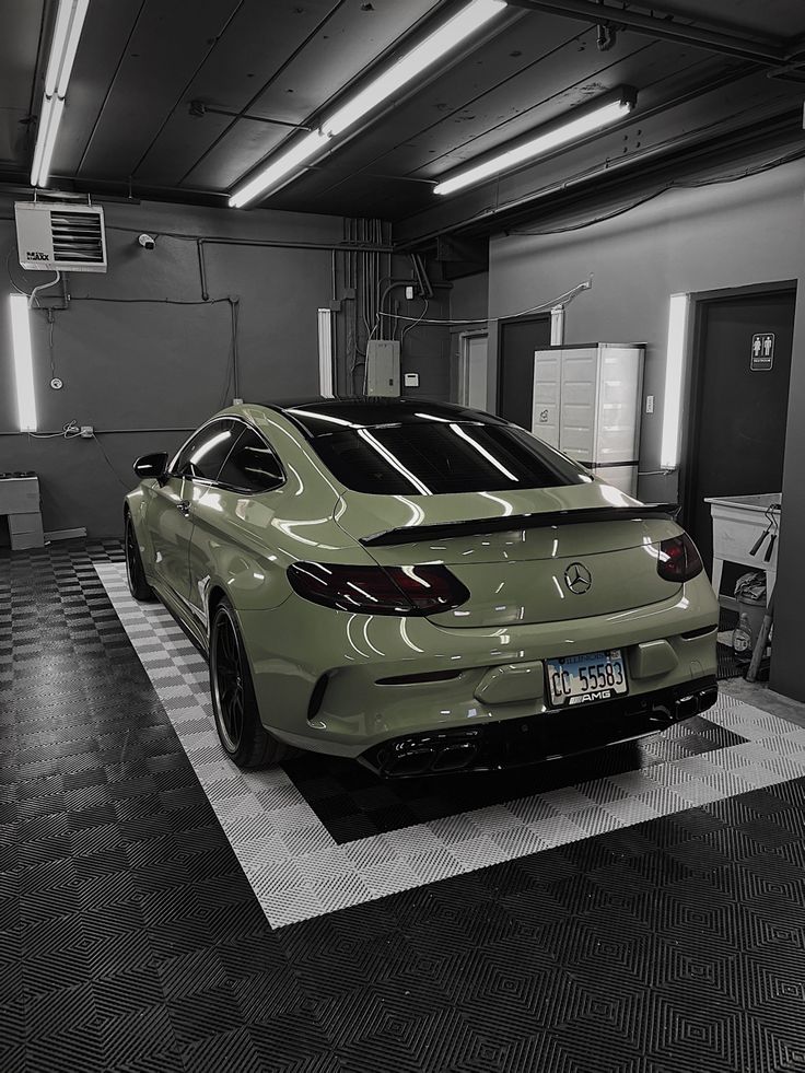 a car is parked in a garage with checkered flooring