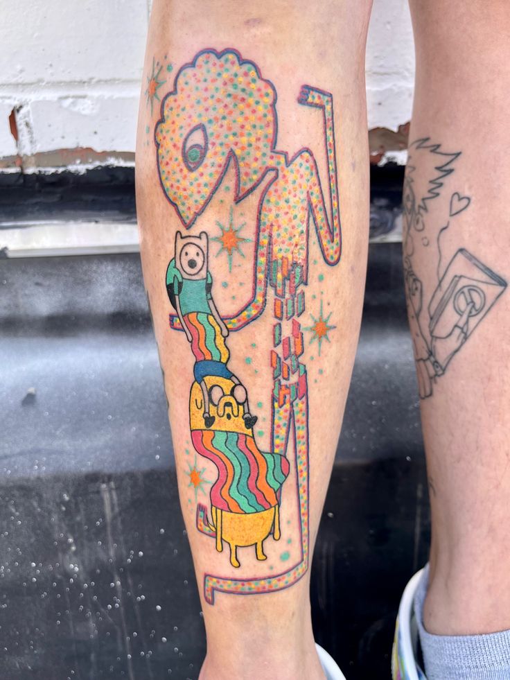 a person with colorful tattoos on their legs