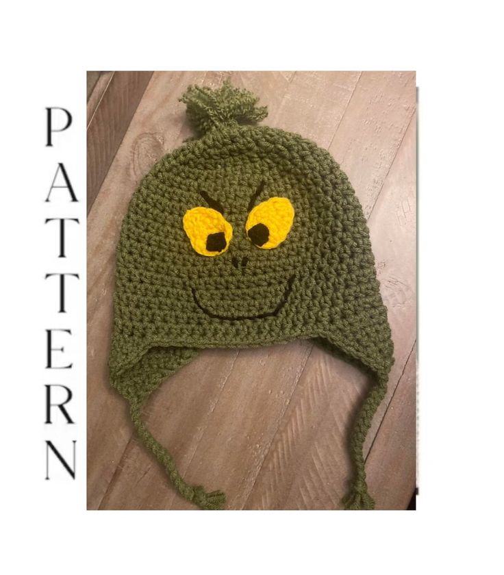 a crocheted green hat with yellow eyes