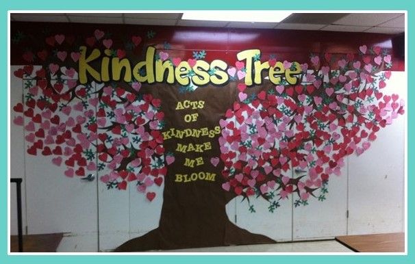 an office with a large tree painted on the wall and tables in front of it