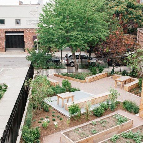 an aerial view of a vegetable garden with raised beds and benches in the foreground