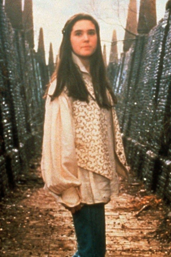 a woman is standing in the middle of a fenced area with bottles on it