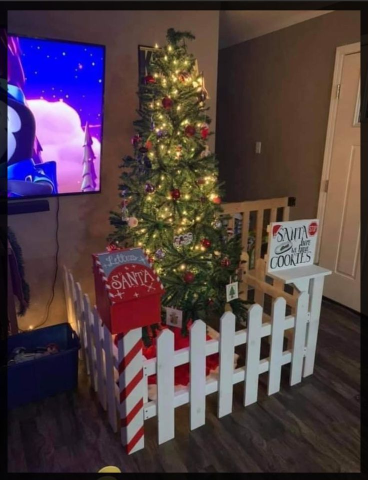 a small christmas tree in front of a tv