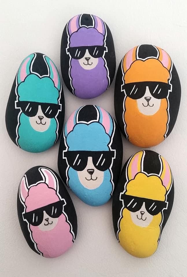 six painted rocks with sunglasses and hats on them