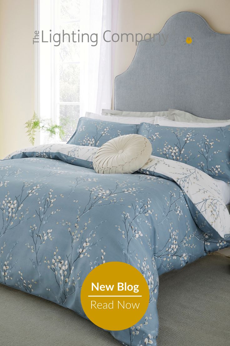 a bed with blue and white comforters in a bedroom next to a window,