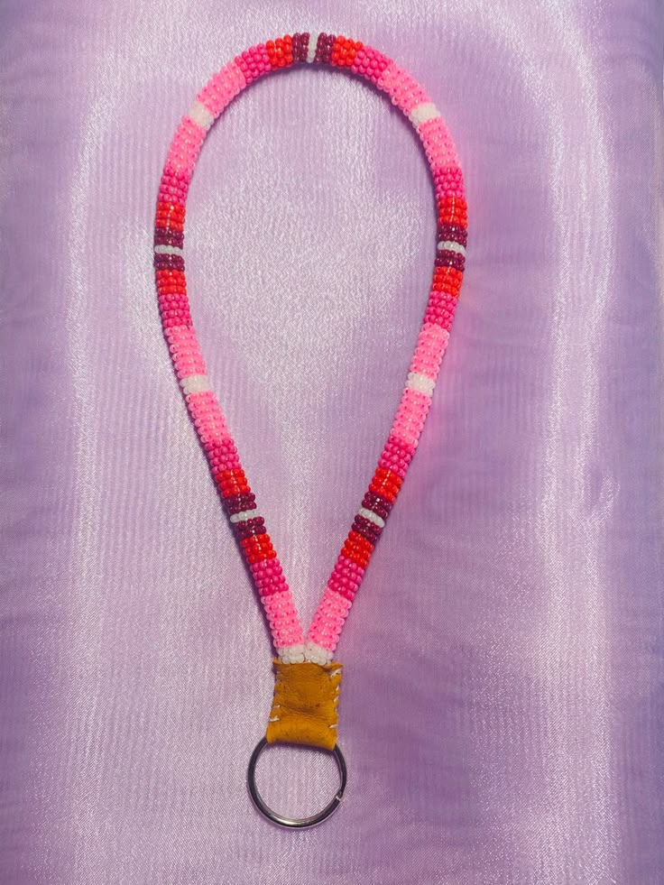 a pink and red beaded lanyard with a metal ring