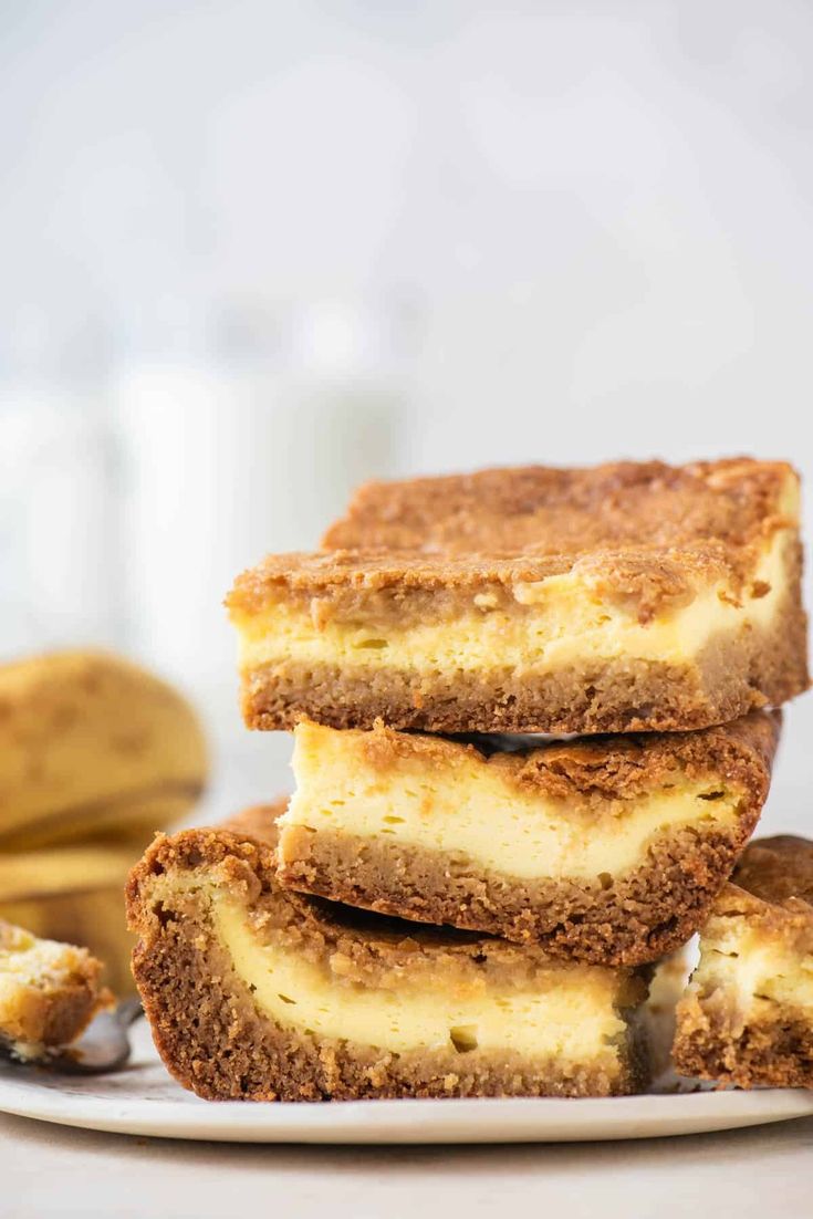 three slices of cheesecake on a plate with bananas in the background