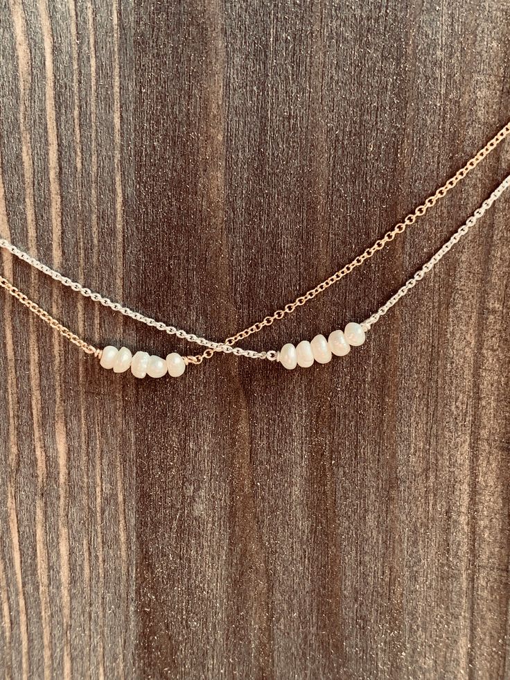 Very dainty Sterling Silver necklace with tiny freshwater Pearls. Perfect for everyday wear, special occasions, bridal jewelry or a brides gift to a bridal party!! Five freshwaterPearls were added to an 18 inch Sterling Silver Chain that adds sparkle to any outfit. Pearls range from 2.5-3mm, making them the perfect way to add class and elegance to your style. Due to the use of natural materials, the necklace you receive may have pearls that vary slightly in shape and size from what is pictured. Everyday Delicate Beaded Necklace With Pearl Pendant, Delicate Everyday Beaded Necklace With Pearl Pendant, Gift Double Strand Beaded Necklace With Pearl Pendant, Double Strand Beaded Necklace With Pearl Pendant As Gift, Dainty Pearl White Beaded Necklaces With Pearl Pendant, Dainty Single Strand Beaded Necklaces For Wedding, Dainty Single Strand Beaded Necklace For Wedding, Delicate Beaded Necklaces With Pearl Drop For Everyday, Delicate Everyday Beaded Necklace With Pearl Chain