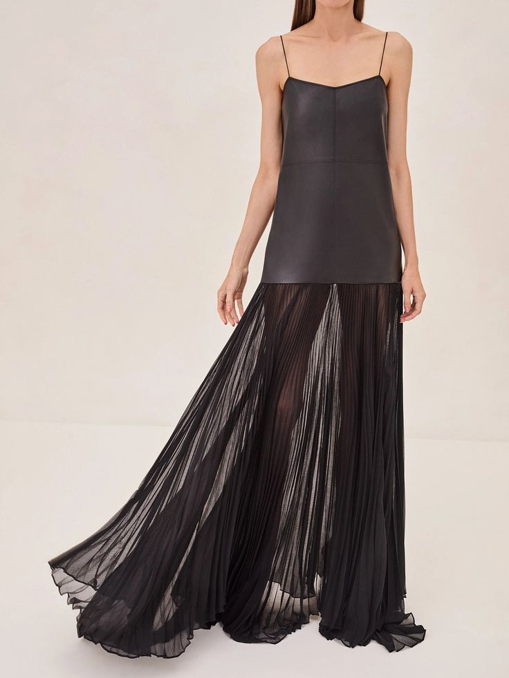 Introducing the Kaleena Dress, a striking blend of modern edge and ethereal elegance. This dress combines the sleek look of vegan leather with a flowing, pleated skirt that moves with every step. The bodice has delicate spaghetti straps that create a flattering silhouette, while the sheer, layered skirt adds a touch of drama and sophistication. Black Pleated Skirt Dress For Evening, Black Evening Pleated Dress, Black Evening Pleated Dress With Pleated Skirt, Black Evening Dress With Pleated Skirt, Floor-length Maxi Dress With Pleated Back For Night Out, Flowy A-line Pleated Evening Dress, Flowy A-line Evening Pleated Dress, Sleek Spring Evening Maxi Dress, Black Pleated Bodice Dress For Evening