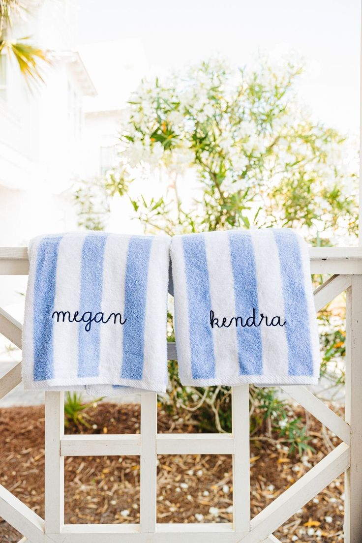 two blue and white towels with the names morgan and kinda written on them in black ink