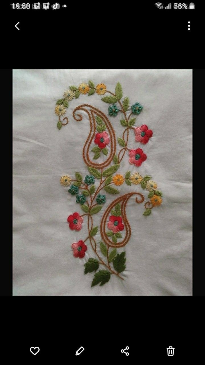 a white table cloth with colorful flowers and leaves on the edges, embroidered onto it